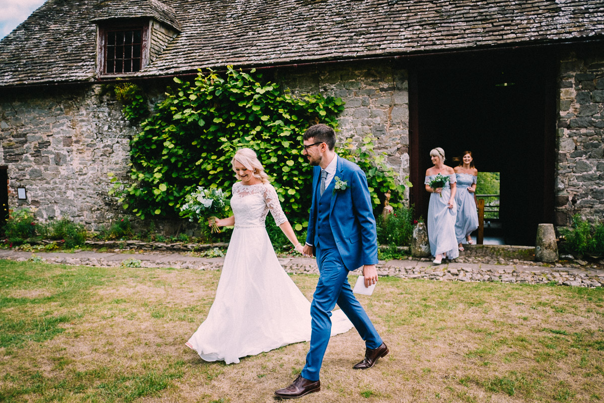 BRIDE AND GROOM WALKING BARN CEREMONY USK CASTLE WEDDING PHOTOGRAPHY